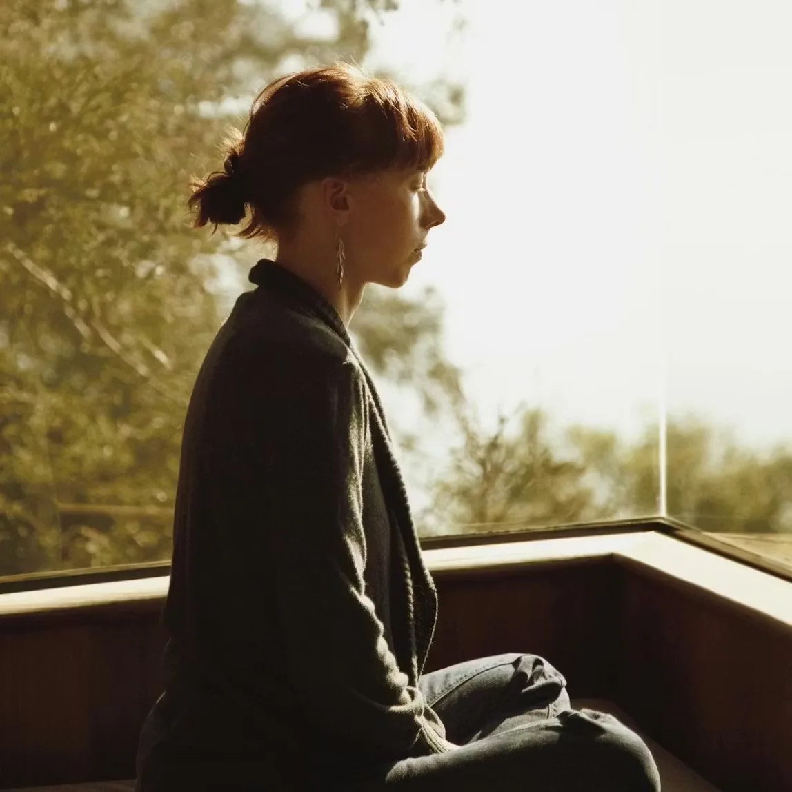 Someone meditating by a window